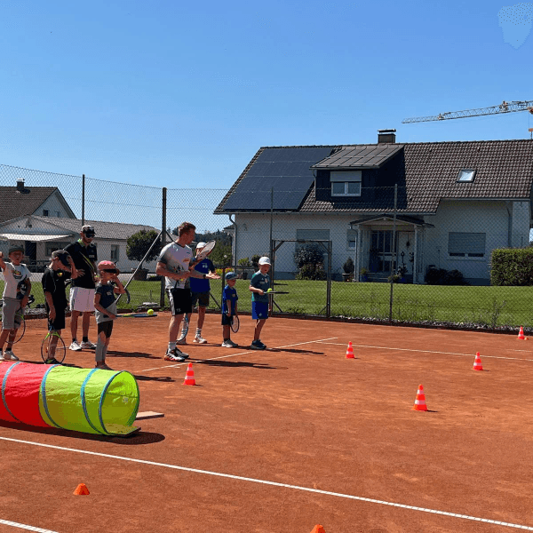 Kinder mit Schlägern am Parcours beim Ferienprogramm 2025 auf dem Sandplatz